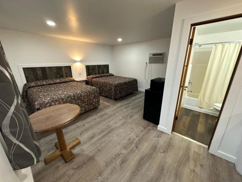 a hotel room with two beds and a table at Lake Aire Motel in Wisconsin Dells