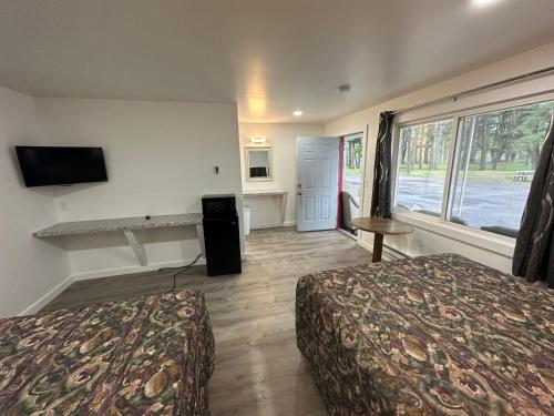 a hotel room with two beds and a television at Lake Aire Motel in Wisconsin Dells