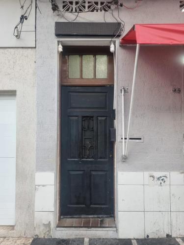 a black door on a building with a red umbrella at TECH Hostel in Sao Paulo