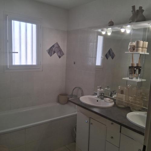 a bathroom with a sink and a bath tub and a sink at Villa d'exception à louer, salon et 2 chambres in Marseillan