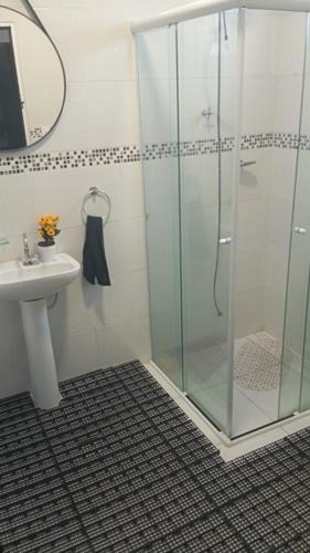 a bathroom with a glass shower and a sink at TECH Hostel in Sao Paulo