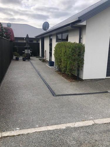 a white building with a parking lot next to it at Modern, Sunny, Central in Motueka