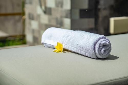 a roll of toilet paper with a yellow flower on a counter at Anggrek villa Ubud in Ubud