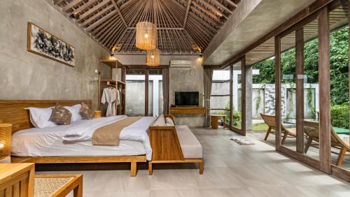 a bedroom with a bed and a tv in it at Anggrek villa Ubud in Ubud