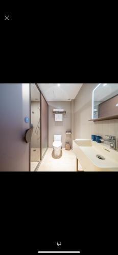 a small bathroom with a toilet and a sink at Hanting Hotel Beijing Tiananmen Square in Beijing