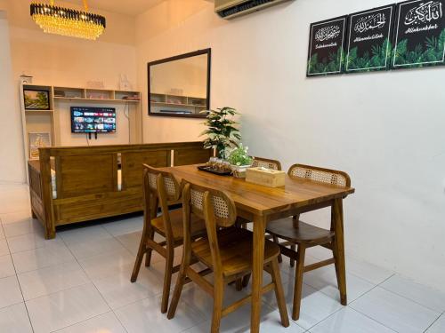 a dining room with a wooden table and chairs at Barakah Homestay Taman Belimbing in Jitra