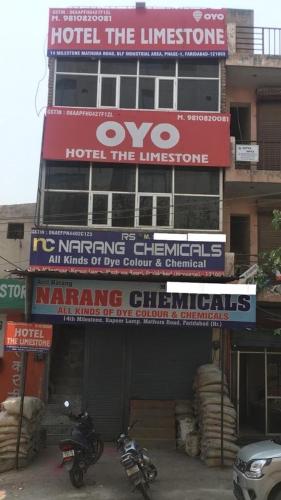 two motorcycles parked in front of a building with signs at Hotel O The Limestone in Indraprast