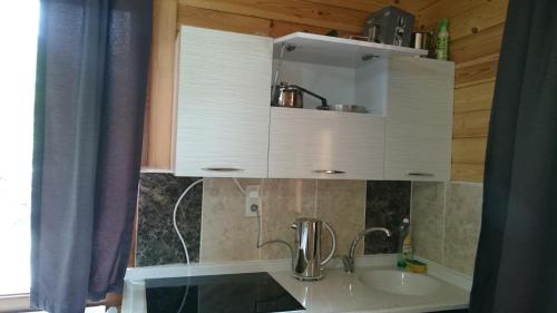 een keuken met witte kasten en een wastafel bij Aslan Apart Evleri in Uzungol