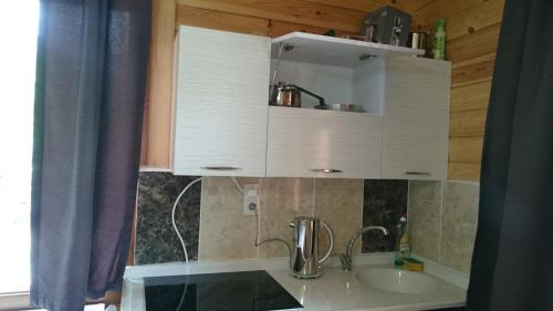 a kitchen with white cabinets and a sink at Aslan Dağ Evleri in Uzungöl