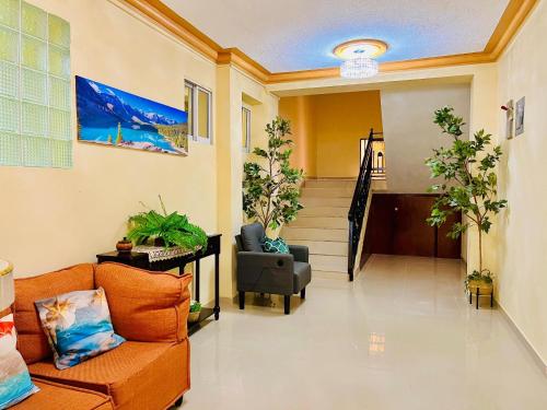 a living room with a couch and a chair at Clora Hotel 