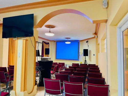 an empty room with chairs and a projection screen at Clora Hotel 