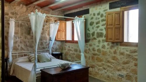 a bedroom with a bed with curtains and a table at Casa De Vacances La Vella Era in Arnés