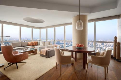 a living room with a couch and a table and chairs at Park Hyatt Guangzhou in Guangzhou