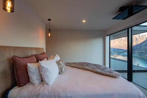 a bedroom with a bed with a view of a mountain at Sky Villa A in Queenstown