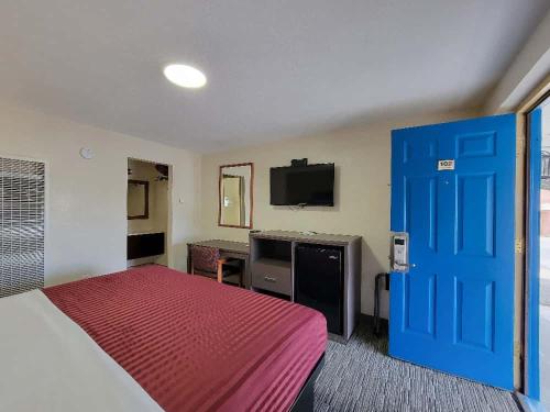 a hotel room with a bed and a blue door at Americas Best Value Inn-Williams/Grand Canyon in Williams