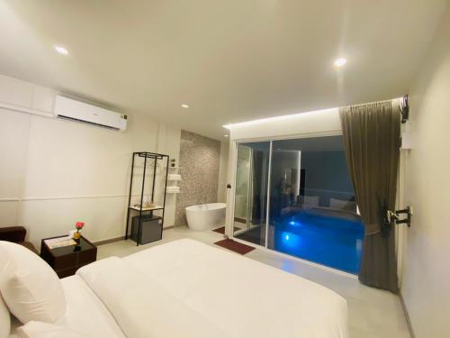 a bedroom with a bed and a bathroom with a tub at KVILLA in Ban Khlong Bang Chak