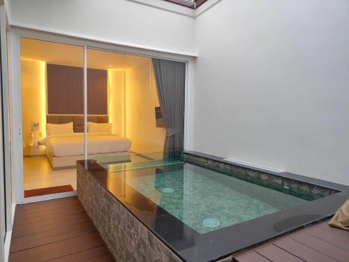 a swimming pool in a hotel room with a bedroom at KVILLA in Ban Khlong Bang Chak