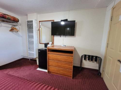 a room with a dresser and a flat screen tv at Americas Best Value Inn-Williams/Grand Canyon in Williams