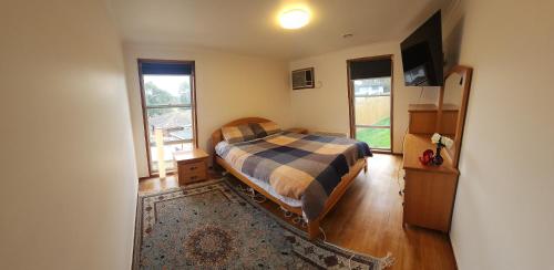 a bedroom with a bed and a tv in it at Large room Queen bed in Melbourne