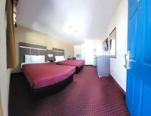two beds in a hotel room with red carpet at Americas Best Value Inn-Williams/Grand Canyon in Williams