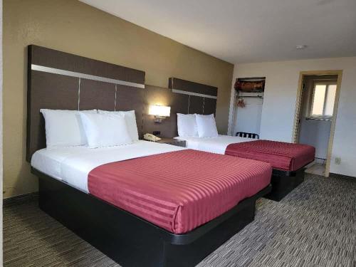 a hotel room with two beds with red sheets at Americas Best Value Inn-Williams/Grand Canyon in Williams