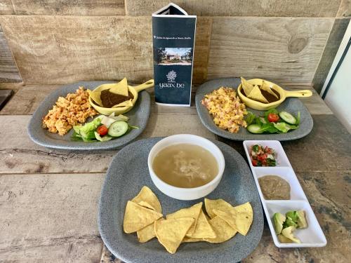 a table with three plates of food with dip and chips at Quinta YaaxBe in Homún