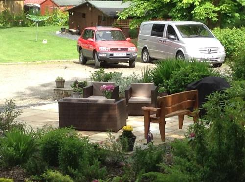 a garden with a bench and a van in a yard at The BurnHowf apartment in Balloch