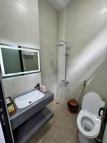 a bathroom with a sink and a toilet at Nhà nghỉ Hoàng Quân in Ðưc Trọng