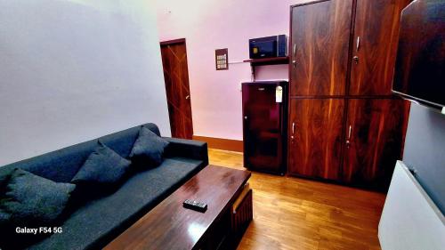 a living room with a couch and a coffee table at Urbania- premium AC PG accommodation for Male in Baranagar