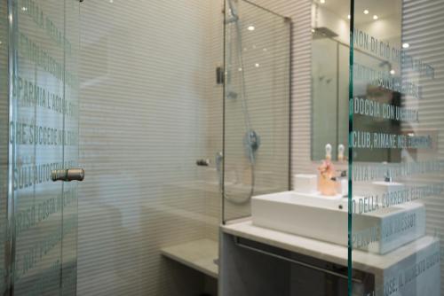 a bathroom with a glass shower and a sink at F53 Kevin's Charming Houses in Alghero