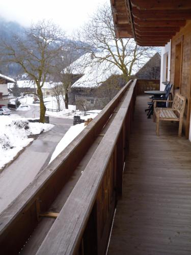 a porch with a wooden railing with snow on the ground at Nagelehof in Ainet