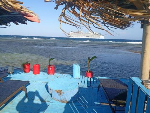 a table on the beach with a cruise ship in the background at Hotel Victoria s Beach House in Roatan