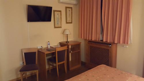 a room with a desk and a table with a television at Hotel del Sol in Motilla del Palancar
