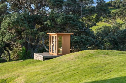 a small building on top of a grassy hill at Waiheke Island Coastal Retreat in Waiheke Island
