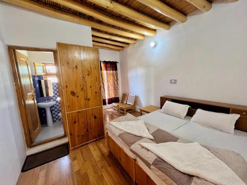 a bedroom with a large bed and a bathroom at Sponbo Guest House, Leh in Leh