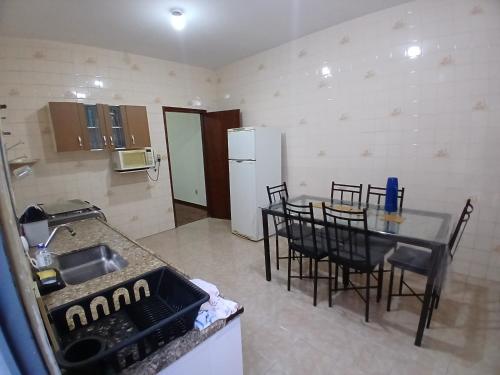 a kitchen with a table and chairs and a refrigerator at Casa de serenidade e paz in Alfenas