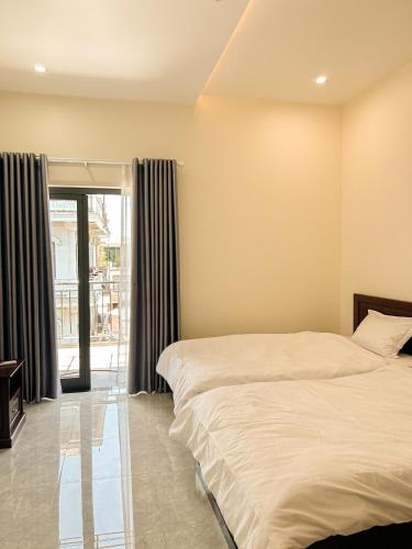 a bedroom with two beds and a large window at Gió Hotel in Huế in Hue