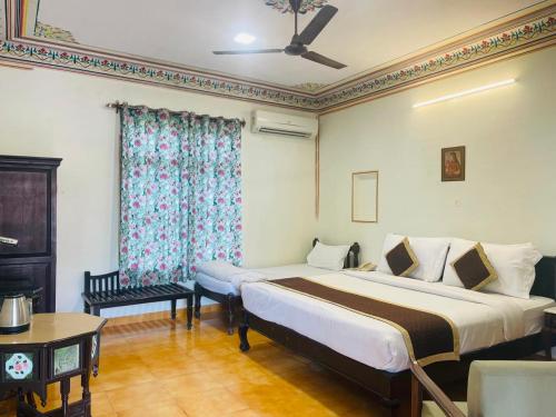Una habitación de hotel con dos camas y una ventana. en Sajjan Bagh Resort, en Pushkar