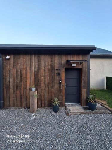 a garage with a blue door and two potted plants at Shi-lu 