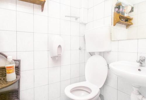 a white bathroom with a toilet and a sink at The City Place Hostel in Dubrovnik