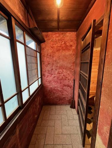 an empty hallway with windows in a building at 坂東商店guest room藍染めと宿 in Wada