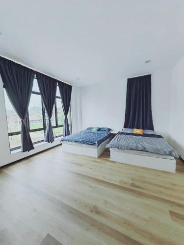 two beds in a room with two windows at My Residence, Bintulu in Bintulu