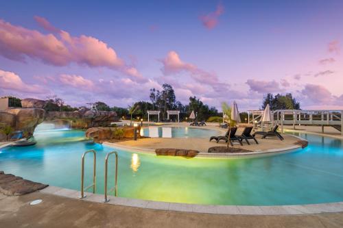 a pool at a resort with chairs in it at BIG4 Saltwater Yamba Holiday Park in Yamba