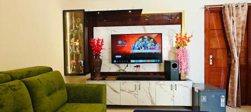 Una sala de estar con un sofá y un televisor. en JAMPANIs NEST FOR FAMILIES AND INDIVIDUALS, en Guntūr