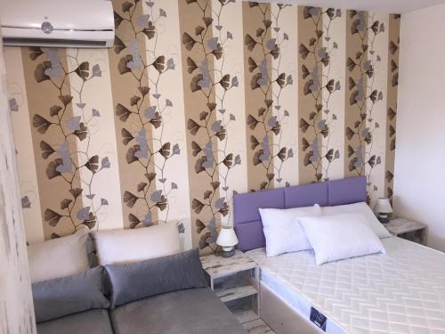 a bedroom with a bed and a couch at Family Hotel Malibu in Chernomorets