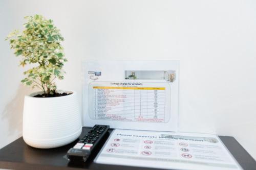 a computer monitor sitting on a desk with a plant at 94Home Donmuang in Bang Khen