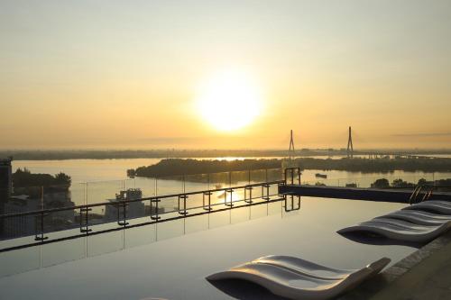 a view of the sunset from a rooftop swimming pool at Charmant Suites a Boutique Hotel Can Tho in Can Tho