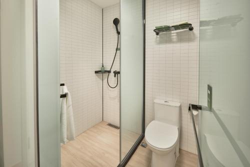 a bathroom with a shower and a toilet at Haiyou Hotel Beijing Wangfujing Xiehe Hospital Store in Beijing
