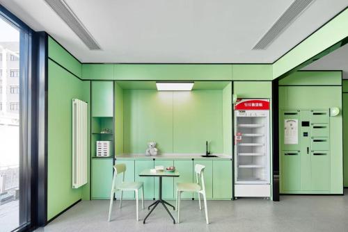 a kitchen with green walls and a table and chairs at Haiyou Hotel Beijing Wangfujing Xiehe Hospital Store in Beijing