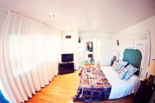 a bedroom with a large bed and a television at Pikes Ibiza in San Antonio